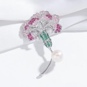 Elegant carnation flower brooch with pink zircons and white pearl on silk background