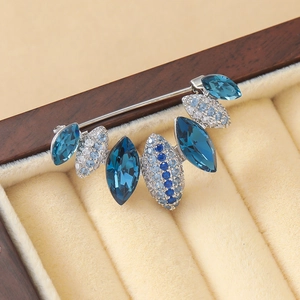 Élégante broche en forme d'éventail avec zircons bleus présentée dans un écrin