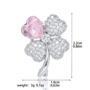 Detailed view of a four-leaf clover brooch with pink gemstone and zircon micro-inlay