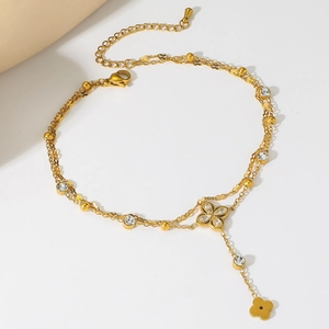 Detail einer zweilagigen Gold-Fußkette mit Zirkon-Blumenanhängern und Karabinerverschluss