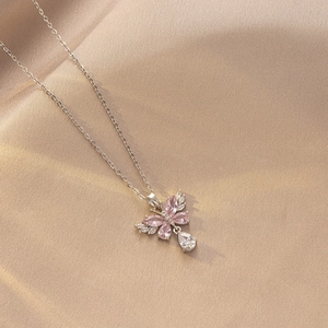 Detalle macro del colgante de mariposa con piedras rosas y cadena de borlas de plata