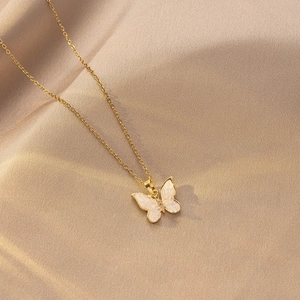 Elegante collar de titanio dorado con colgante de mariposa sobre seda de lujo