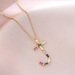 Détail du pendentif lettre J doré serti de zircons multicolores sur chaîne fine