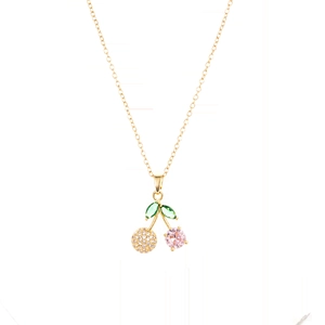 Détail du collier pendentif cerise avec pierres roses et feuilles vertes sur chaîne dorée