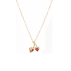 Détail d'un collier doré avec pendentif cerise en pierres rouges en cœur et petits zircons