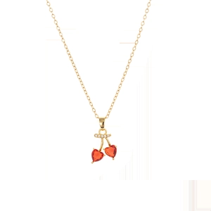 Détail macro d'un pendentif cerise en or avec pierres rouges en forme de cœur sur une chaîne