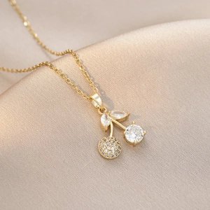 Collier pendentif cerise avec zircons brillants sur fond de tissu satiné champagne