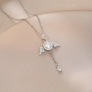 Silver angel wings necklace with heart zircon pendant and shimmering tassel detail