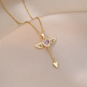 Detail of Cupid angel wing necklace with purple heart zircon on gold silk background
