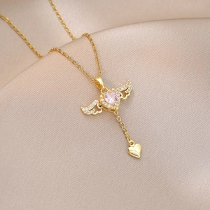 Detailed macro view of angel wing heart necklace with pink gem on silk fabric