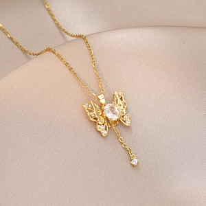 Macro shot of gold butterfly pendant with sparkling oval gemstone and pavé crystal wings