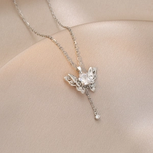 Detail of silver butterfly pendant with rectangular crystal and tassel on satin
