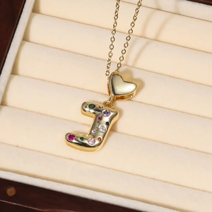 Collier pendentif lettre J doré avec zircons colorés et fermoir cœur sur boîte en velours
