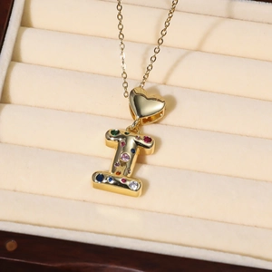 Nahaufnahme der Goldkette mit Herzanhänger und buntem Zirkonia-Buchstabe I Anhänger