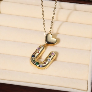 Detailansicht einer goldenen Kette mit buntem Zirkonia-Anhänger in massiver U-Form