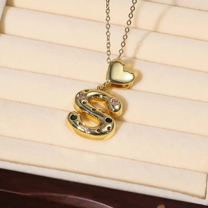 Detaillierte Makroansicht des goldenen Buchstaben-S-Anhängers mit bunten Edelsteinen