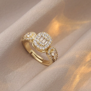 Bague ajustable dorée avec zircons étincelants sur fond de satin de champagne