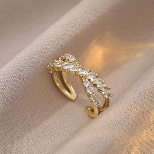 Détail de la bague nœud dorée avec zircone sur fond de soie de couleur champagne