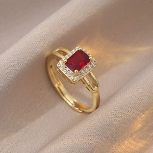 Gros plan détaillé d'une bague avec pierre rouge rectangulaire sur satin de soie champagne