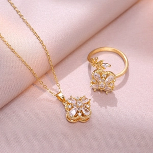 Gros plan d'un ensemble de bijoux tournesol doré avec zircons sur fond de tissu rose