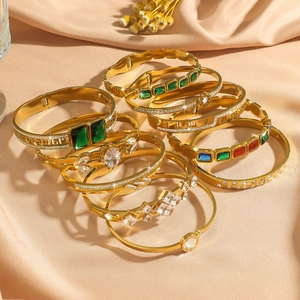 Gold-plated stainless steel bracelet set with green emerald zirconia on silk background