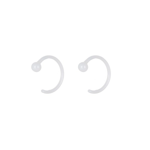 Close-up of translucent white C-shaped ceramic earrings with smooth rounded ends