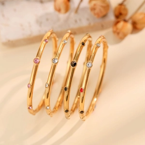 Set aus vier goldenen Titanstahl-Armreifen mit bunten Strasssteinen für Damen Mode