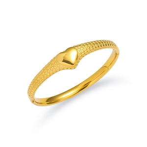 Elegant gold stainless steel bangle featuring a heart center and textured dot patterns