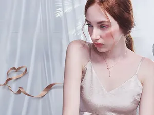 Detail view of a dainty gold chain necklace featuring moon and star pendants on a model