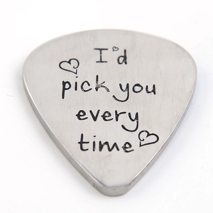 Macro detail of brushed stainless steel guitar pick with romantic quote engraving