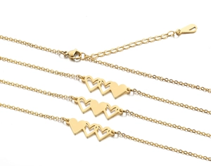 Détail du collier coeur triple doré montrant le fermoir mousqueton et la chaîne réglable
