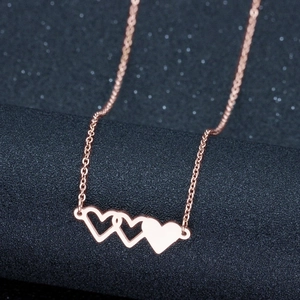 Détail du collier en or rose avec trois pendentifs en forme de cœurs entrelacés