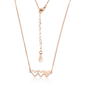 Détail du pendentif triple cœur en or rose montrant la marque 18KGP sur la chaîne