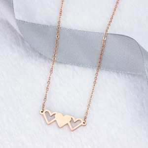 Détail du collier à trois cœurs en or rose sur soie luxueuse et fausse fourrure
