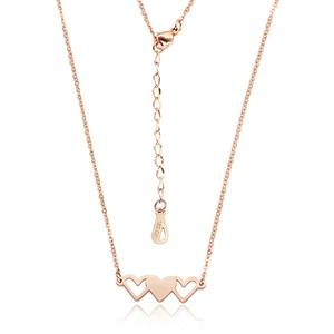 Détail du pendentif triple cœur en or rose avec gravure 18KGP sur l'extension