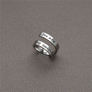 Gros plan détaillé sur bague spirale argentée avec texte you are my sunshine et soleil