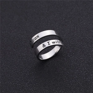 Détail macro d'une bague spirale argentée gravée avec le slogan I Can and I Will