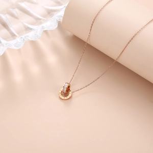 Detail of rose gold double ring pendant with Roman numerals and sparkling white zircons