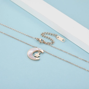 Close-up of rose gold moon and star necklace with iridescent mother of pearl inlay