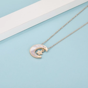 Detailed view of rose gold star and crescent moon pendant with shell inlay and zircon