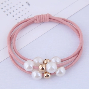 Detail of pink three-strand elastic hair ties with white pearls and gold bead accents