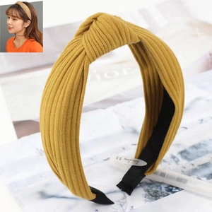 Macro shot of mustard yellow knitted twist headband with textured rib pattern