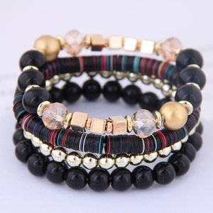 Bracciale multistrato bohémien con perline nere, accenti dorati e ciondoli di cristallo