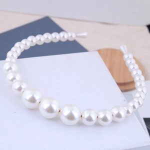 Detail showing gradient pearls on a golden metal headband for elegant wedding hair styles