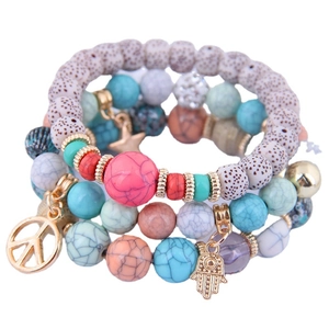Bracciale bohémien multistrato con perline di turchese, pietre laviche e ciondoli hamsa