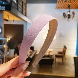 Close-up of pink padded headband with grainy frosted texture in a cafe setting