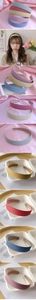 Close-up of Morandi matte headbands in sky blue and dusty pink on silk fabric