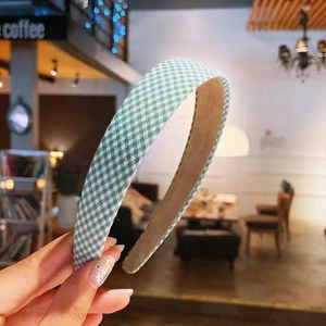 Close-up of a Korean style green and white gingham fabric headband with non-slip lining