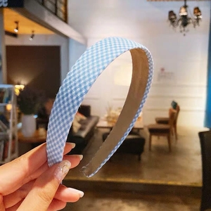 Detailed view of blue and white gingham fabric headband with brown non-slip inner lining