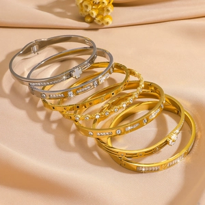Set of six titanium steel clover and star patterned bracelets on champagne satin fabric